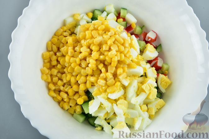 Фото приготовления рецепта: Салат из крабовых палочек с кукурузой, плавленым сыром и огурцом - шаг №9