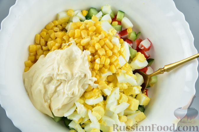 Фото приготовления рецепта: Салат из крабовых палочек с кукурузой, плавленым сыром и огурцом - шаг №11