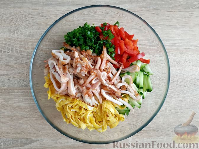 Фото приготовления рецепта: Салат с жареными кальмарами, огурцами, болгарским перцем и яичными блинчиками - шаг №16
