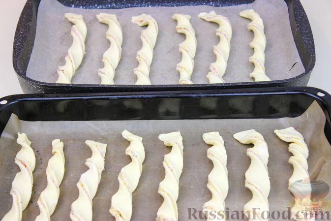Фото приготовления рецепта: Слоёные палочки-спиральки с ветчиной и сыром - шаг №9