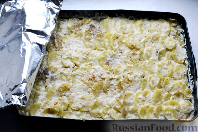 Фото приготовления рецепта: Минтай, запечённый с картофелем и луком, в сливках - шаг №14