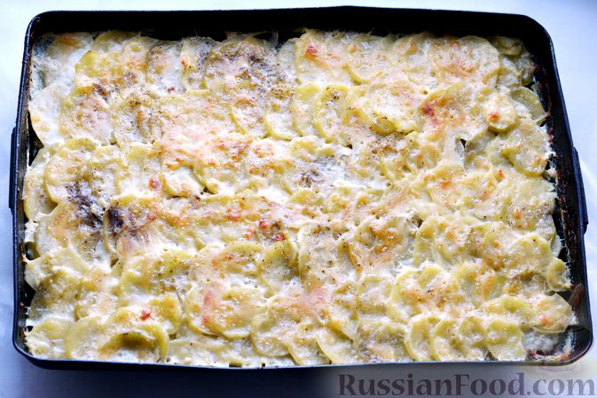 Фото приготовления рецепта: Минтай, запечённый с картофелем и луком, в сливках - шаг №15