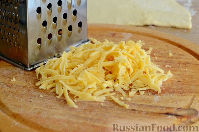 Фото приготовления рецепта: Сосиски в слоёном дрожжевом тесте, с сыром и жареным луком - шаг №4