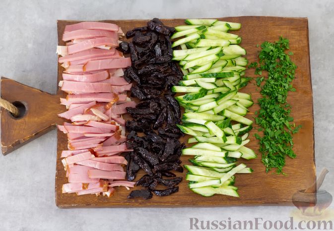 Фото приготовления рецепта: Салат с ветчиной, черносливом, огурцами и консервированным зелёным горошком - шаг №2