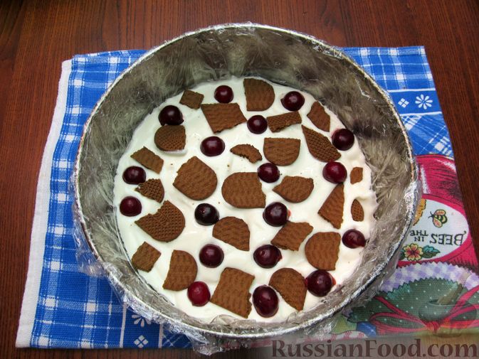 Фото приготовления рецепта: Творожно-йогуртовый торт с вишней и печеньем (без выпечки) - шаг №14