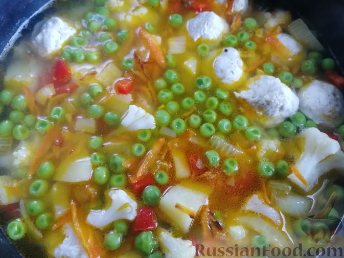 Фото приготовления рецепта: Суп с куриными фрикадельками, цветной капустой и зеленым горошком - шаг №9