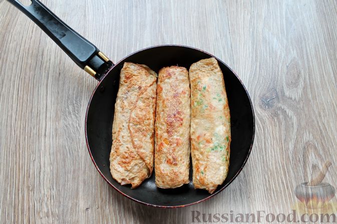 Фото приготовления рецепта: Омлетные рулетики с болгарским перцем и зеленью - шаг №12