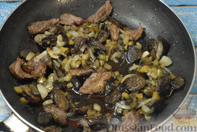 Фото приготовления рецепта: Говядина, тушенная с лесными грибами, маринованными огурцами, коньяком и йогуртом - шаг №12