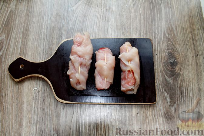 Фото приготовления рецепта: Куриные рулетики с ветчиной и моцареллой, тушенные в томатном соусе - шаг №7