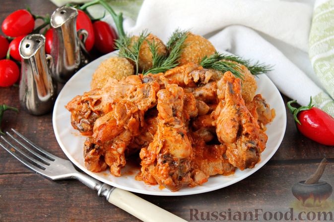 Фото приготовления рецепта: Куриные крылышки, тушенные в сметанно-томатном соусе - шаг №13