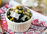 Фото к рецепту: Салат из селёдки с консервированным горошком и маслинами
