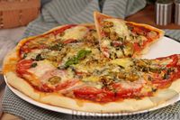 Фото к рецепту: Пицца с тунцом, помидорами и оливками